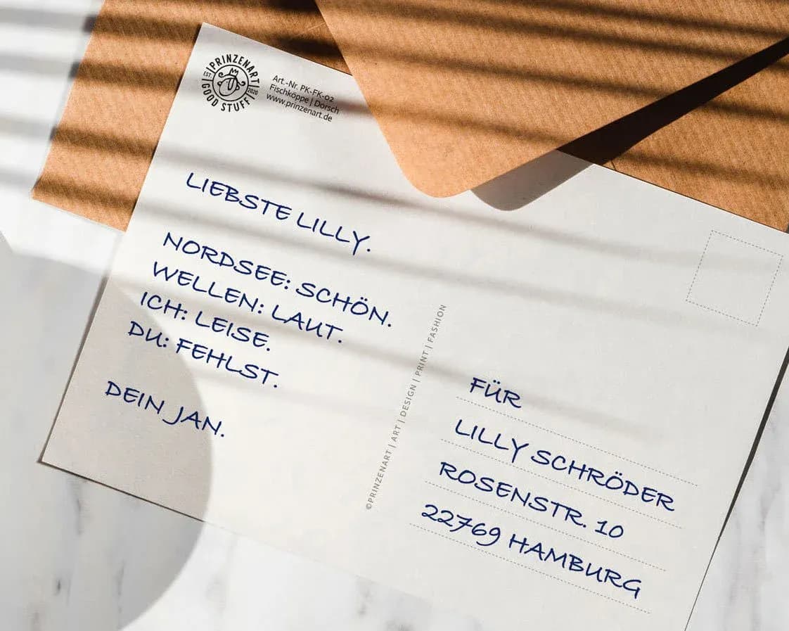 Postkarte mit braunem Umschlag liegt auf Tisch